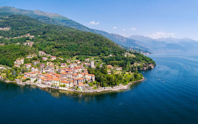 Aerial view of townscape by sea against sky