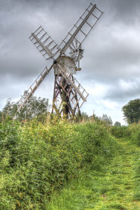 Traditional windmill on field against sky