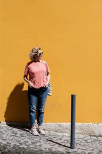 Rear view of woman standing against wall