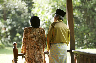 Rear view of couple standing in gazebo at yard