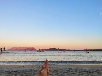 Person on beach against clear sky