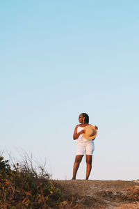 Rear view of woman standing against sky