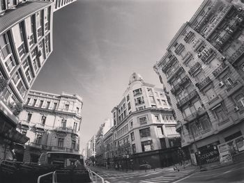 Cars on street amidst buildings in city against sky