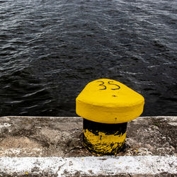 High angle view of yellow sign on pier over lake