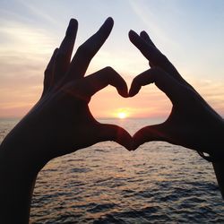 Cropped image of woman looking at sunset