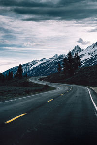 Road by snowcapped mountain against sky