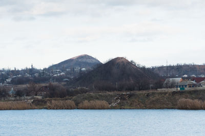 Scenic view of river by mountains against sky