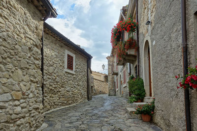 Narrow street amidst buildings against sky