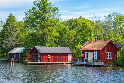 Houses by lake and buildings against sky