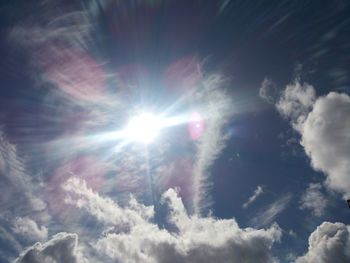 Low angle view of sun shining in sky