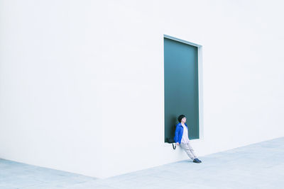 Woman standing against white wall