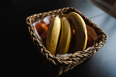 High angle view of fruit in basket on table against black background