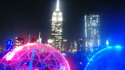 Illuminated city against sky at night