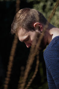 Close-up portrait of man holding cigarette against blurred background