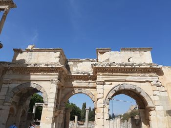 Low angle view of old ruin building against blue sky