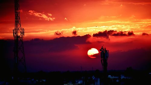 Silhouette electricity pylon against romantic sky at sunset