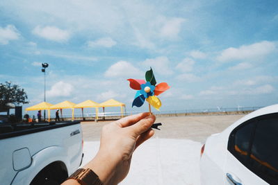 Midsection of person holding umbrella against sky