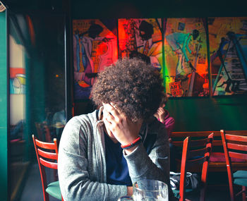 Young man sitting on table in restaurant