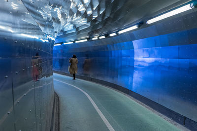 Woman walking in illuminated subway station