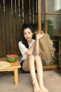 Young woman sitting on sofa at home