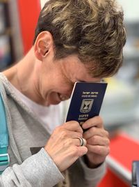 Close-up of smiling woman holding passport