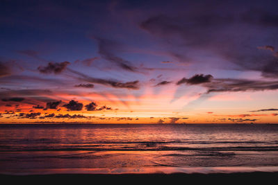 Scenic view of sea against dramatic sky during sunset