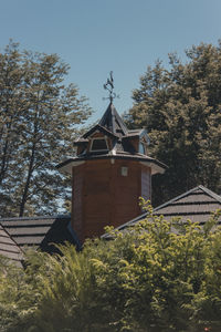 Low angle view of trees and building against sky