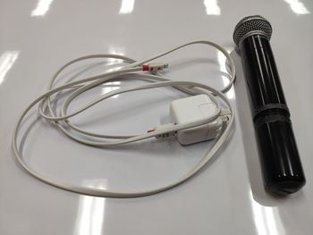 High angle view of microphone and cable on table