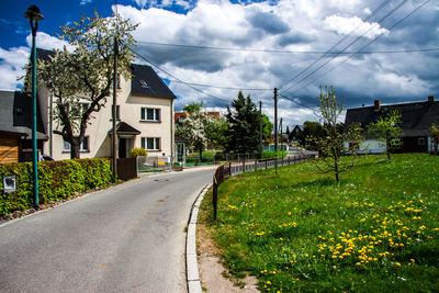 Street amidst houses and buildings against sky