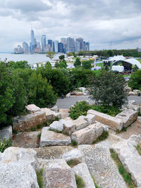 View of trees and buildings against cloudy sky