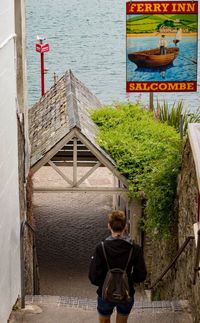 Rear view of woman standing by staircase