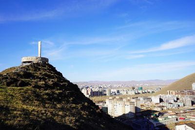 Buildings in town against blue sky