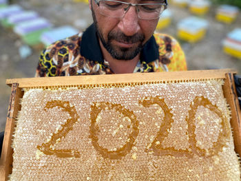 Mature man holding honeycomb with numbers