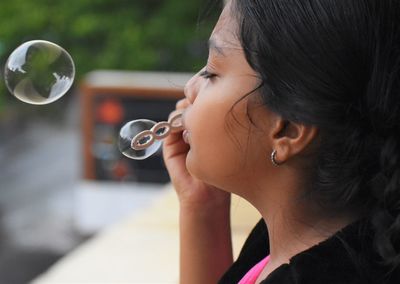 Close-up portrait of girl holding bubbles