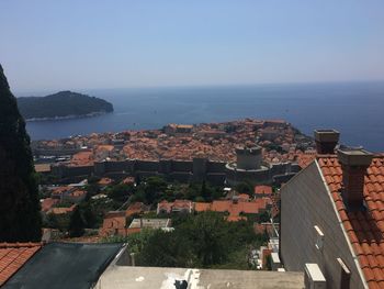 High angle view of townscape by sea against sky