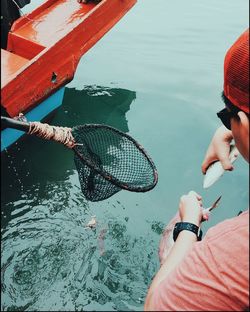 Low section of men fishing in lake