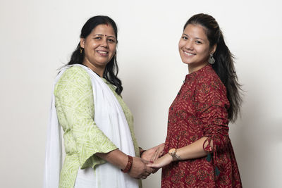Portrait of a smiling young woman against white background