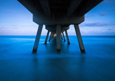 Scenic view of pier over sea against blue sky