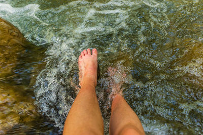 Low section of woman feet in water