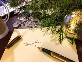 High angle view of pen with envelope by christmas decoration on table