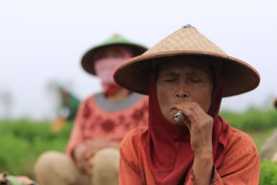 Senior woman smoking marijuana joint at farm
