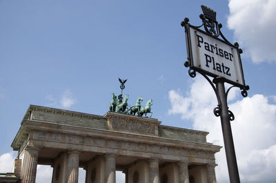 Low angle view of sign board against blue sky