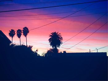 Silhouette palm trees against sky at sunset