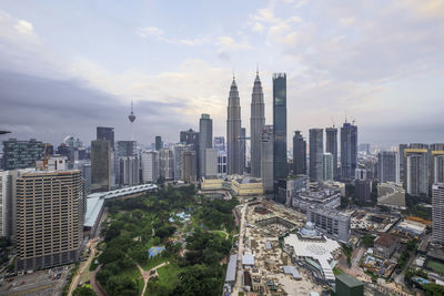 Modern buildings in city against cloudy sky