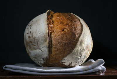 Close-up of bread on table against black background