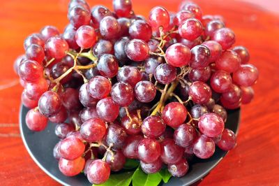 High angle view of grapes in bowl on table