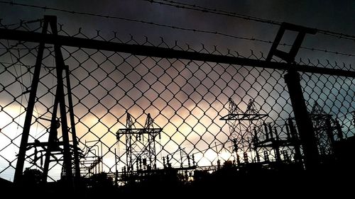 Silhouette of electricity pylon against sky