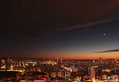 Illuminated cityscape against sky at night