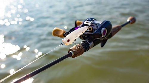 Close-up of person paragliding against sea