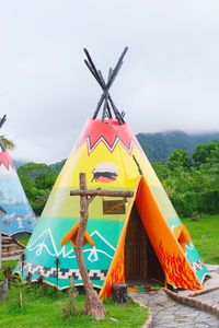 Traditional windmill on field against sky